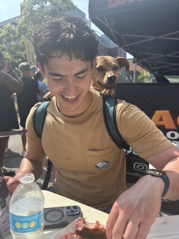 Brendan Tan-Fahed smiling outdoors with a dog
